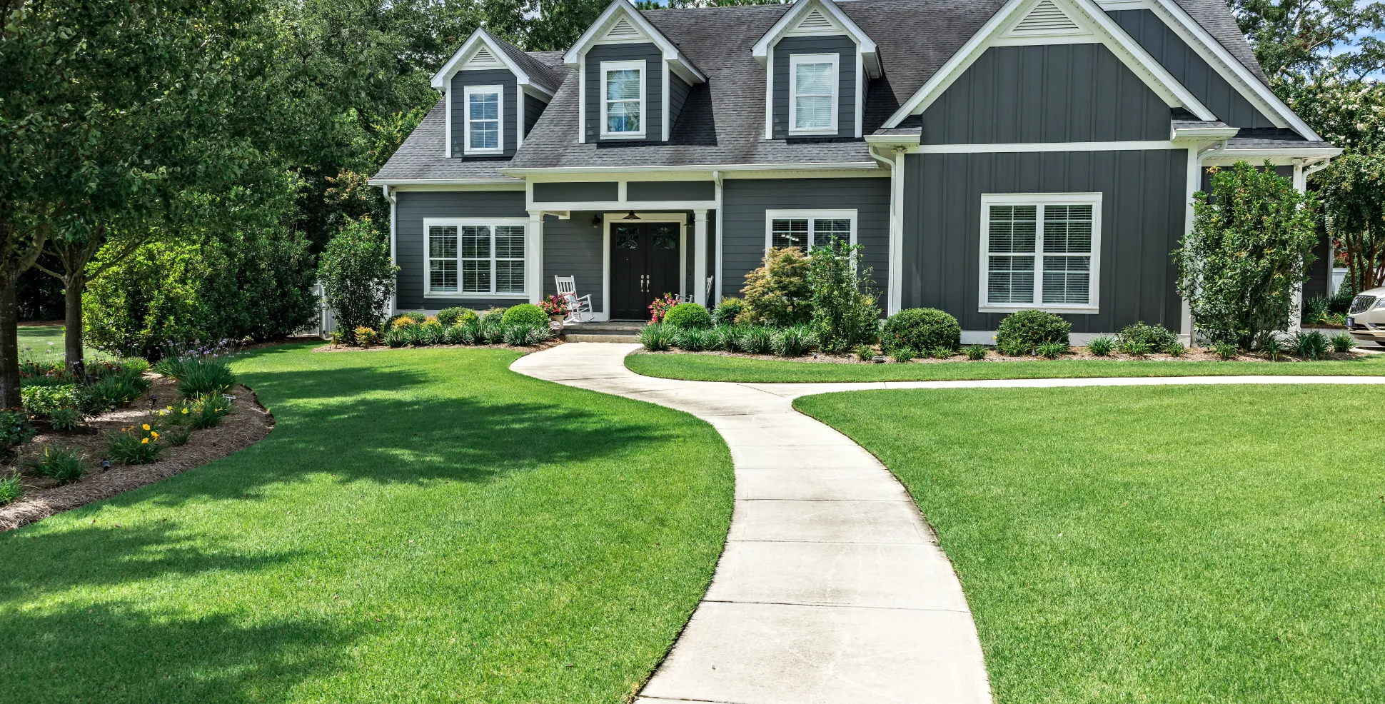Beautiful residential concrete walkway and driveway curving toward a modern home in Los Angeles