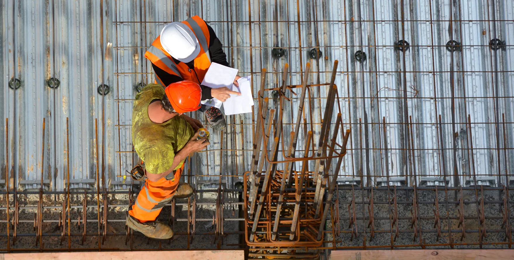 Engineers reviewing structural rebar layout before concrete placement on commercial project