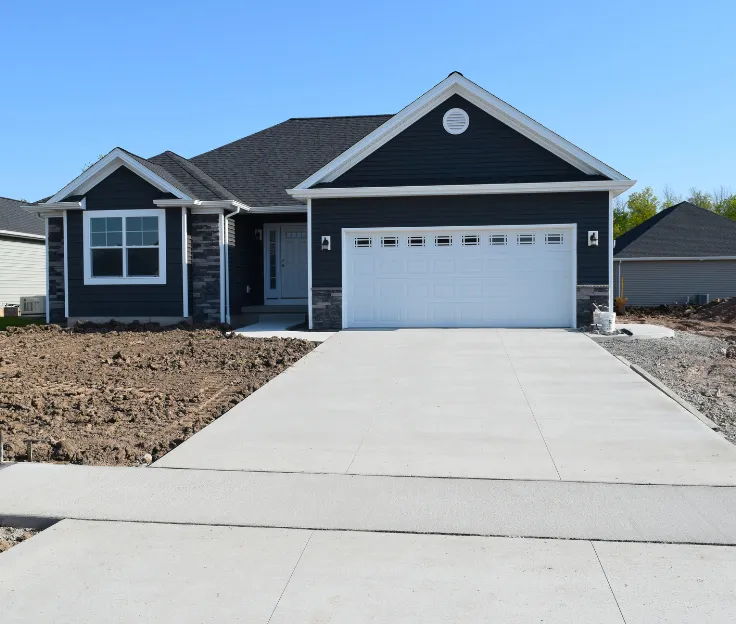 Completed concrete driveway leading to residential garage with smooth, reinforced finish