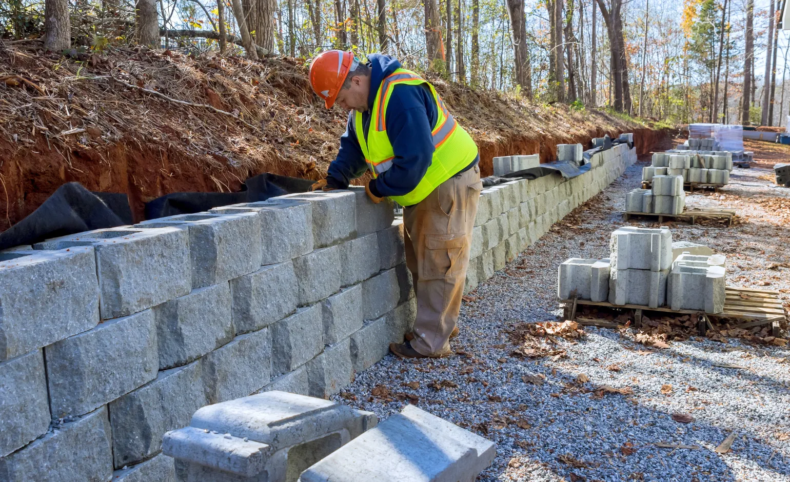 Concrete Pro LA crew installing a block retaining wall along a sloped hillside